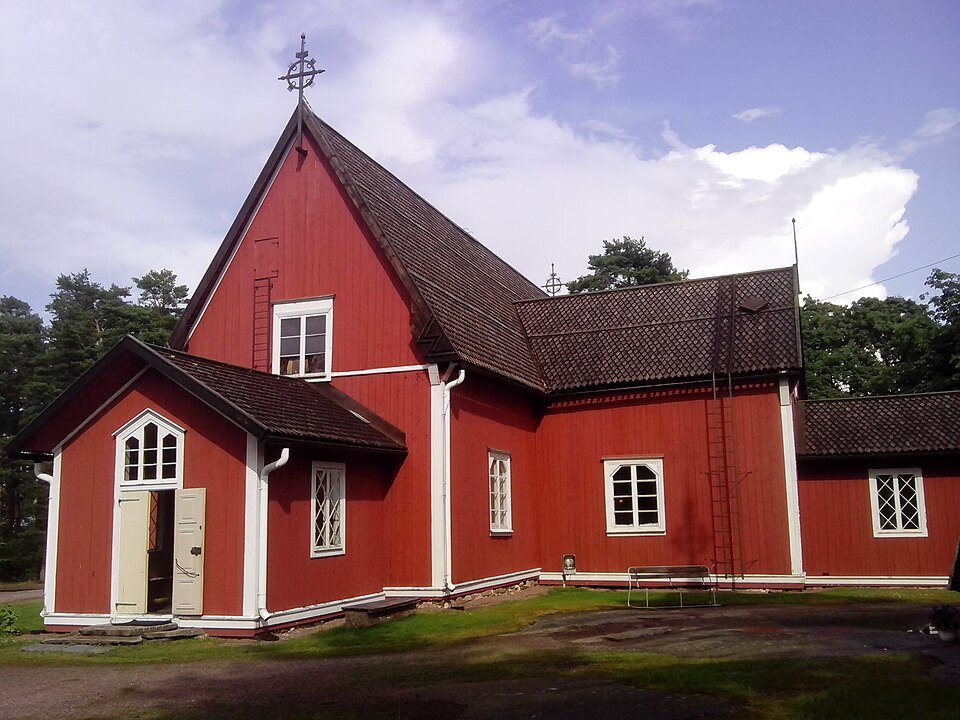 Punainen puinen ristikirkko, jonka katto on paanua