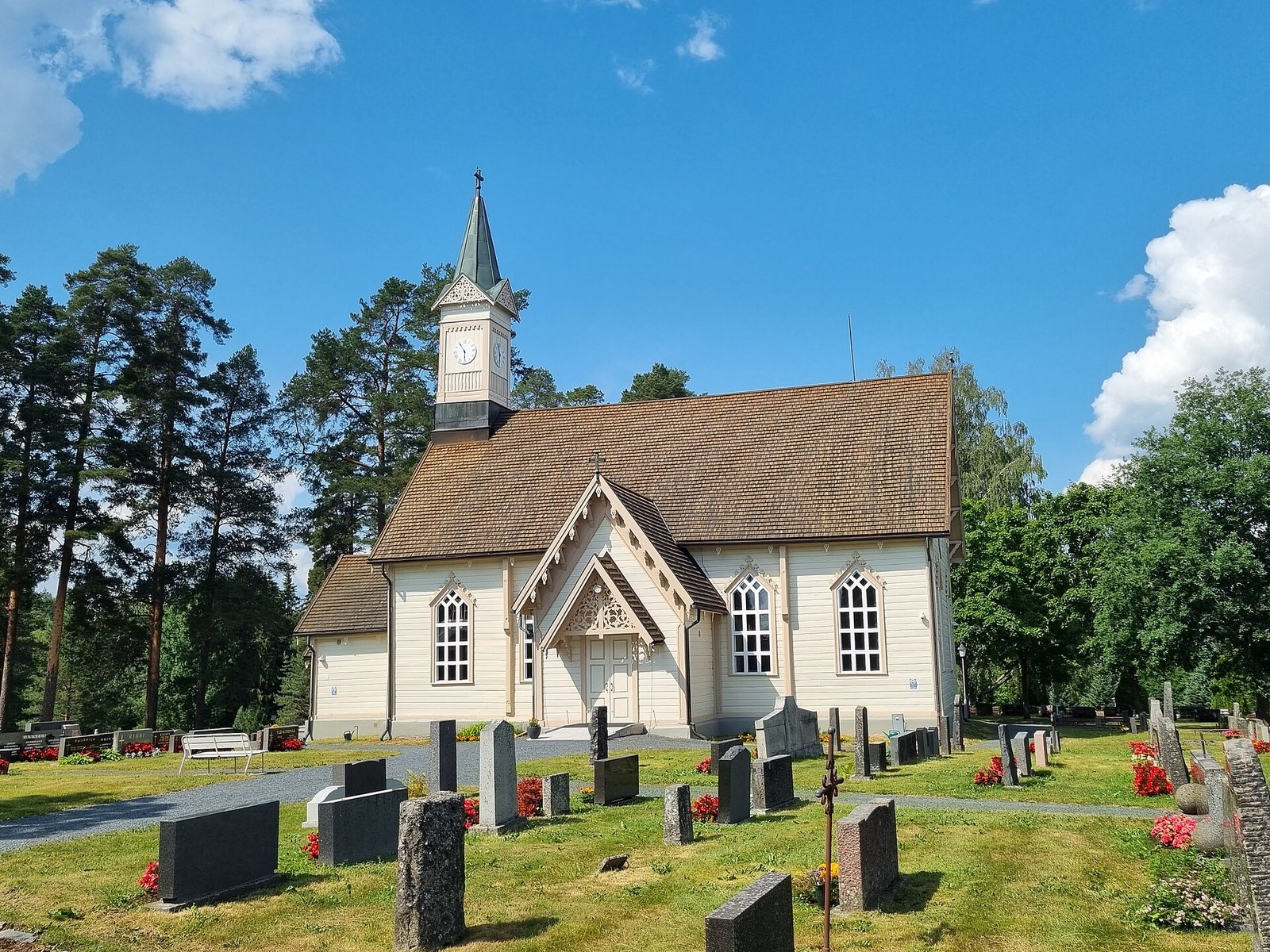 Jokioisten valkoinen puukirkko ja hautausmaa kesäpäivänä
