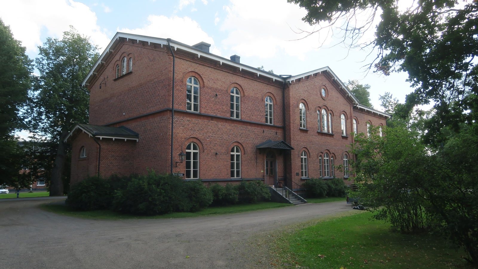 Punatiilinen Mustialan maatalousoppilaitoksen rakennus puistoympäristössä