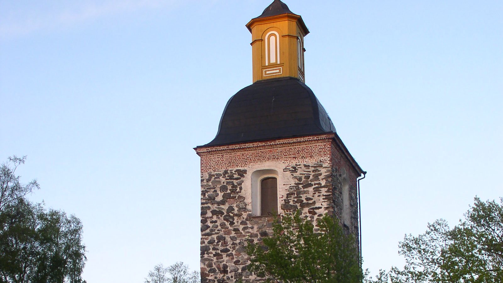 Tammelan harmaakivikirkon kellotorni kesäiltana