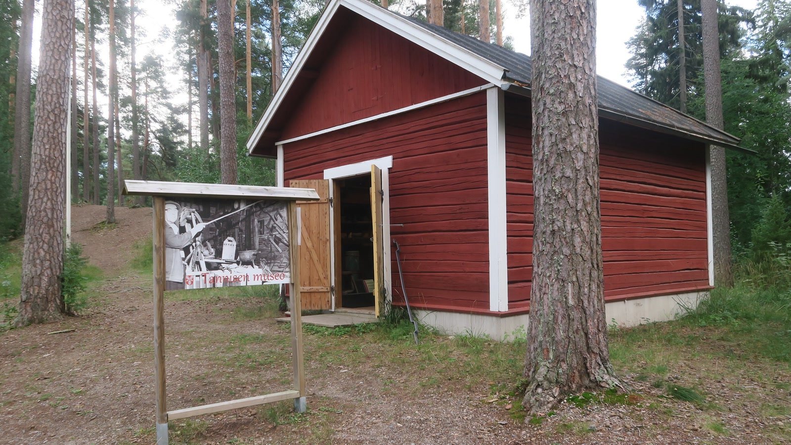 Punainen museorakennus ja Tammelan museon opaste Saaren kansanpuistossa