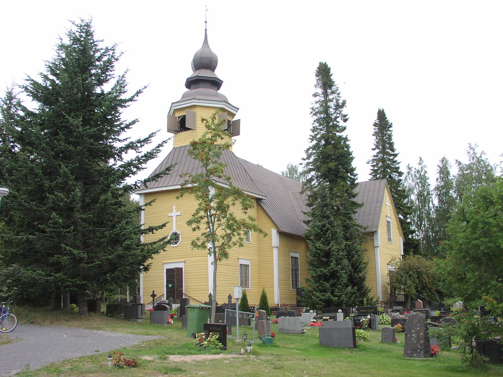 Keltainen puukirkko, barokkitorni ja hautausmaa
